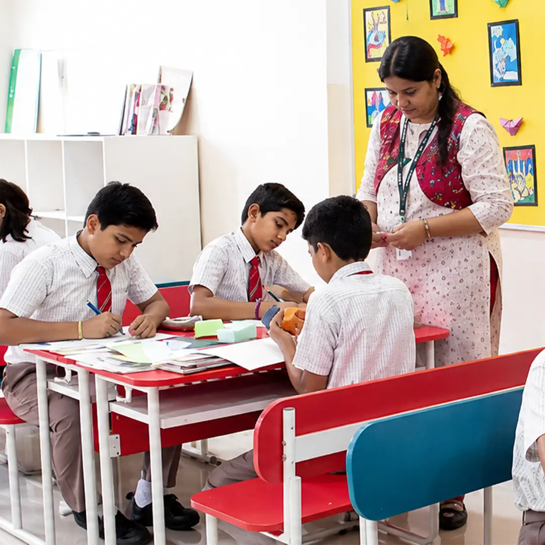 Teacher guiding students in a classroom at NPS Sadashivanagar